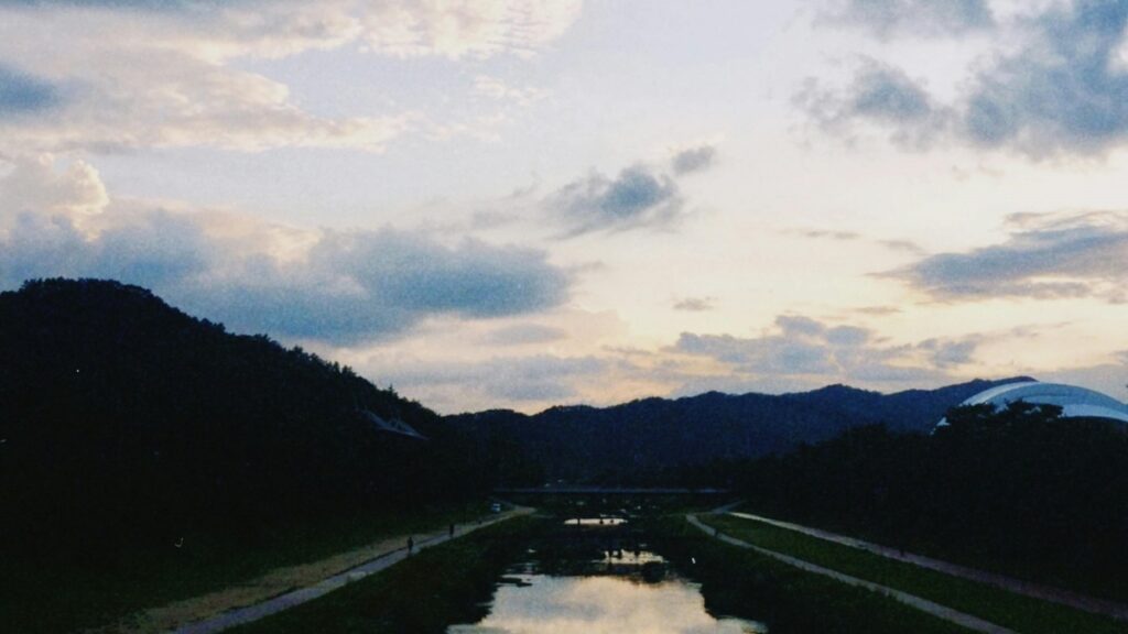 이 사진은 아름다운 야경을 보여줍니다. 구름이 흩날리는 하늘과 어둡게 어둡게 덮인 산과 함께, 조용한 강물이 반짝입니다. 소셜 미디어의 경쟁 세계에서 "Byte App이 TikTok을 이기려 했던 시도"를 알아보세요.